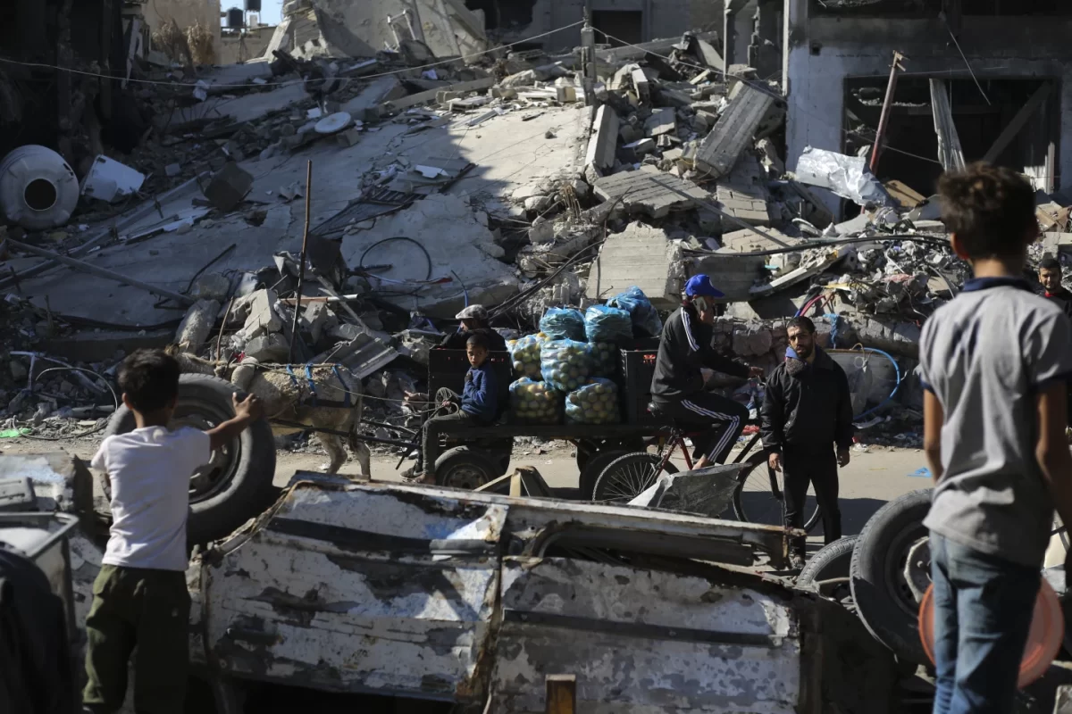Palestinians+walk+by+a+destroyed+building+during+the+fragile+ceasefire