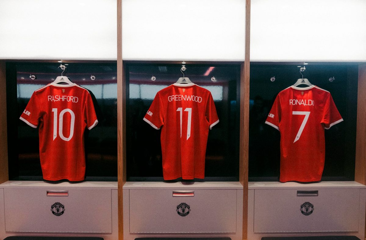 a display case with three red soccer jerseys