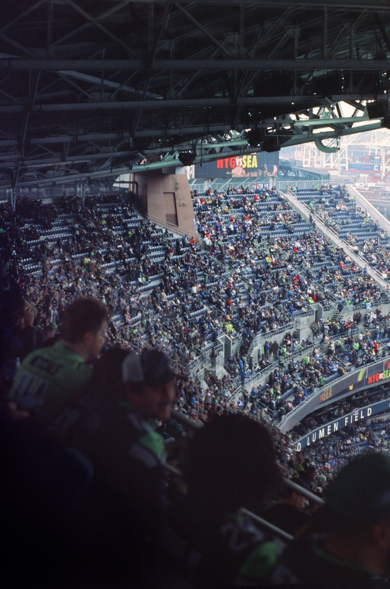 a large crowd of people sitting in a stadium